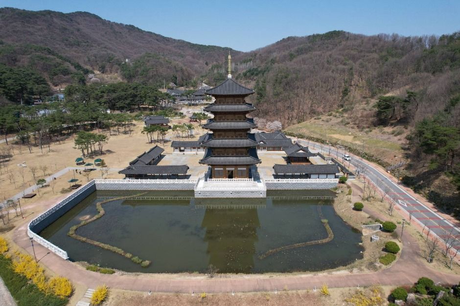 Aerial view of the five-story wooden Tower of Peace behind its pond in Samyeongdaesa Park